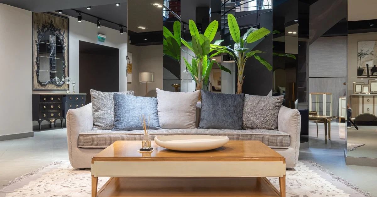 Salon spacieux et moderne avec une décoration élégante, comprenant un canapé confortable, une table basse et des plantes d'intérieur.