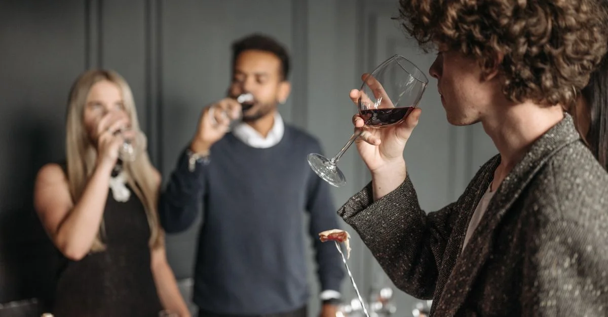 Un groupe divers d'adultes profitant d'un événement de dégustation de vin à l'intérieur avec un arrière-plan flou.