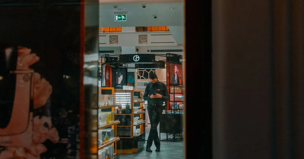 Homme dans un magasin de détail à Saint-Pétersbourg utilisant un téléphone. Vue intérieure à travers la vitre.
